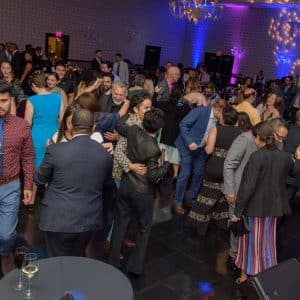 People dancing and enjoying drinks on a crowded and lively dance floor